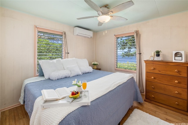 68-17 Laau Paina Pl, Waialua, HI 96791 - bedroom featuring an AC wall unit, wood finished floors, and a ceiling fan
