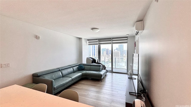 629 Keeaumoku St Unit 2310, Honolulu, HI 96814 - living room with wood finished floors, an AC wall unit, a textured ceiling, and floor to ceiling windows