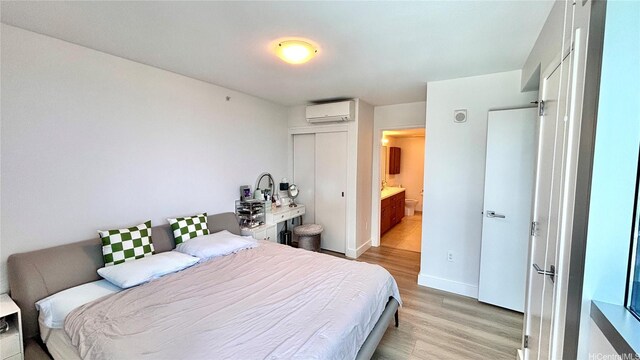 629 Keeaumoku St Unit 2310, Honolulu, HI 96814 - bedroom with a wall mounted AC, light wood finished floors, and a closet