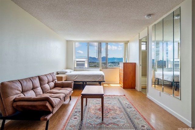 1060 Kamehameha Hwy Unit 2308B, Pearl City, HI 96782 - living room with light wood-style floors, a textured ceiling, a mountain view, expansive windows, and cooling unit