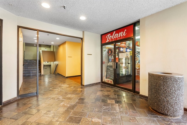 2499 Kapiolani Blvd Unit 2708, Honolulu, HI 96826 - corridor featuring a textured ceiling, stairs, stone tile flooring, and recessed lighting