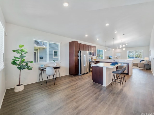 91-1512 Ulaula Loop, Ewa Beach, HI 96706 - kitchen featuring stainless steel appliances, wood finished floors, a kitchen bar, light countertops, and healthy amount of natural light