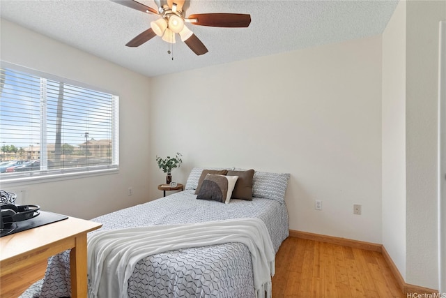 94-496 Kupuohi St Unit 2102, Waipahu, HI 96797 - bedroom featuring light wood-type flooring, a ceiling fan, and a textured ceiling