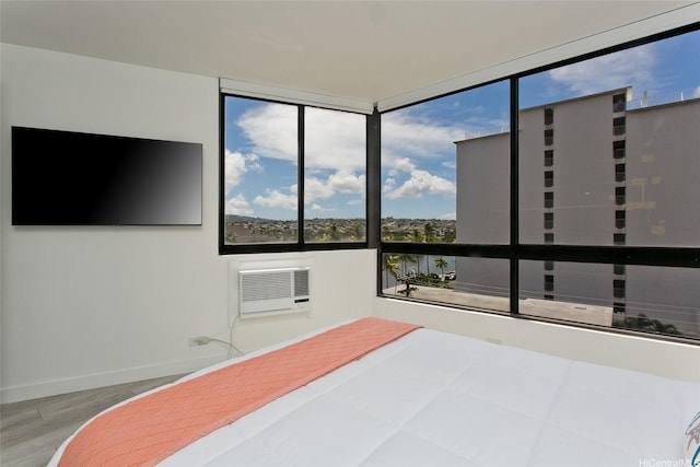 320 Liliuokalani Ave Unit 602, Honolulu, HI 96815 - bedroom featuring multiple windows, a wall unit AC, and wood finished floors