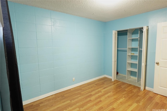 94-49 Waipahu St Unit 314, Waipahu, HI 96797 - unfurnished bedroom with light wood finished floors, a textured ceiling, and a closet