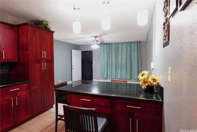 94-49 Waipahu St Unit 314, Waipahu, HI 96797 - kitchen with dark brown cabinets, dark countertops, a ceiling fan, decorative light fixtures, and light tile patterned floors