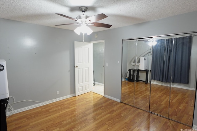 94-49 Waipahu St Unit 314, Waipahu, HI 96797 - unfurnished bedroom featuring wood finished floors, a closet, a textured ceiling, and a ceiling fan