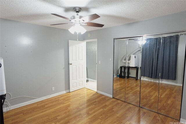 94-49 Waipahu St Unit 314, Waipahu, HI 96797 - unfurnished bedroom with wood finished floors, a closet, a textured ceiling, and a ceiling fan