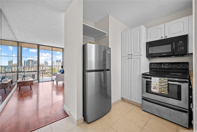 1561 Pensacola St Unit 1104, Honolulu, HI 96822 - kitchen featuring stainless steel appliances, white cabinetry, a view of skyline, a textured ceiling, and expansive windows