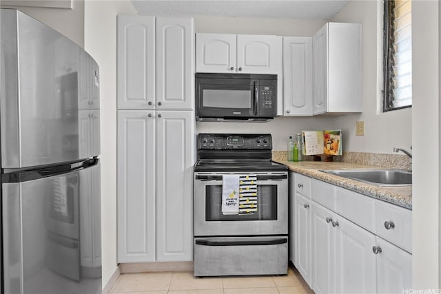 1561 Pensacola St Unit 1104, Honolulu, HI 96822 - kitchen with stainless steel appliances, white cabinets, light tile patterned floors, and light countertops