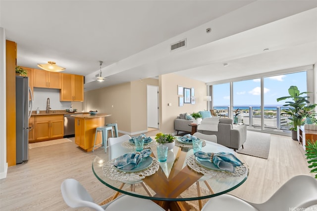 1296 Kapiolani Blvd Unit Ii2407, Honolulu, HI 96814 - dining room with light wood-style flooring, a water view, and ceiling fan