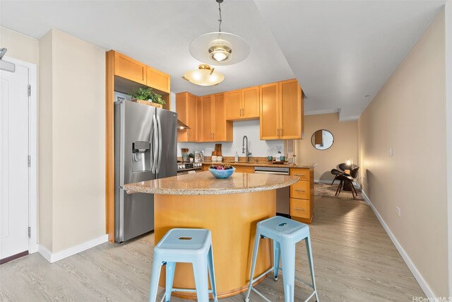 1296 Kapiolani Blvd Unit Ii2407, Honolulu, HI 96814 - kitchen with appliances with stainless steel finishes, light wood finished floors, a kitchen island, and a breakfast bar