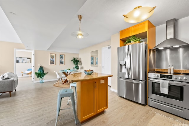 1296 Kapiolani Blvd Unit Ii2407, Honolulu, HI 96814 - kitchen featuring appliances with stainless steel finishes, wall chimney range hood, light wood-style flooring, and a kitchen island