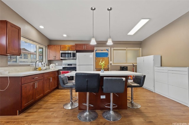 94-555 Awamoi St, Waipahu, HI 96797 - kitchen featuring stainless steel appliances, a breakfast bar area, light countertops, light wood-style floors, and recessed lighting