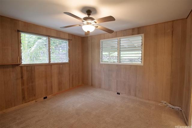 2410 Halenoho Pl, Honolulu, HI 96816 - carpeted empty room featuring plenty of natural light, a ceiling fan, and wooden walls