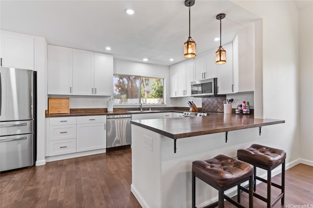 91-1186 Namahoe St, Kapolei, HI 96707 - kitchen with stainless steel appliances, wooden counters, a kitchen breakfast bar, dark wood-type flooring, and a peninsula
