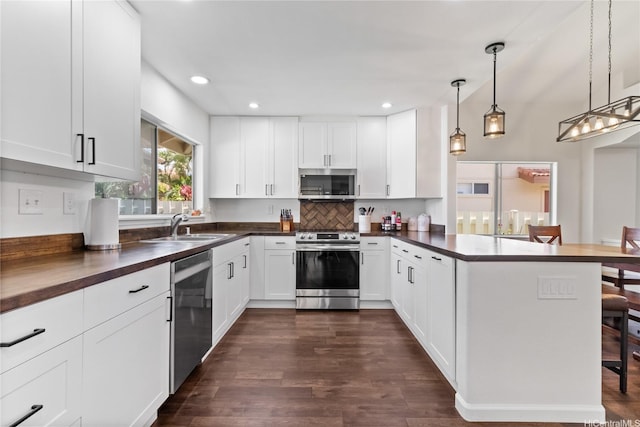 91-1186 Namahoe St, Kapolei, HI 96707 - kitchen with stainless steel appliances, a peninsula, tasteful backsplash, a kitchen bar, and white cabinetry