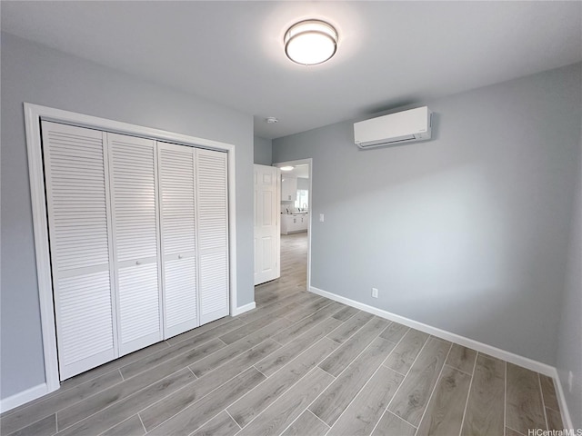 811 20th Ave, Honolulu, HI 96816 - unfurnished bedroom with an AC wall unit, light wood-type flooring, and a closet