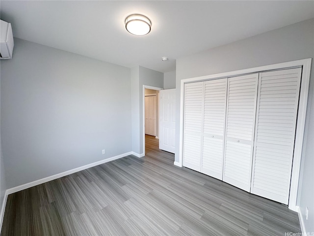 811 20th Ave, Honolulu, HI 96816 - unfurnished bedroom with wood finished floors, a closet, and a wall mounted air conditioner