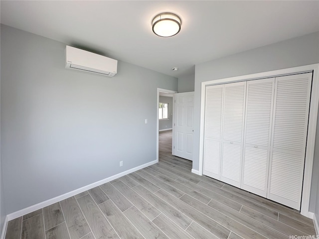 813 20th Ave, Honolulu, HI 96816 - unfurnished bedroom with a wall unit AC, light wood-style floors, and a closet