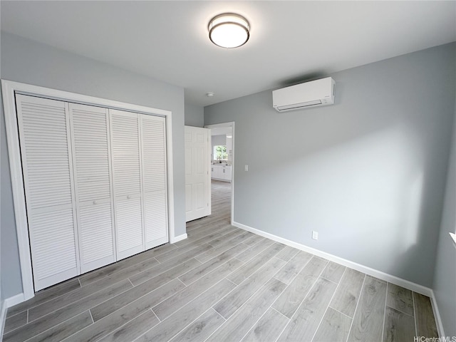 813 20th Ave, Honolulu, HI 96816 - unfurnished bedroom with a wall unit AC, light wood-style floors, and a closet