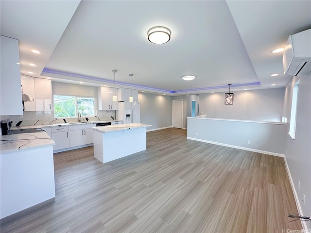 813 20th Ave, Honolulu, HI 96816 - kitchen featuring a tray ceiling, white fridge with ice dispenser, light wood finished floors, decorative backsplash, and hanging light fixtures