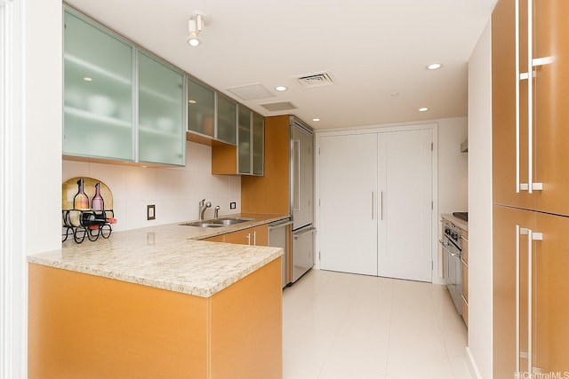 1177 Queen St Unit 2906, Honolulu, HI 96814 - kitchen featuring appliances with stainless steel finishes, a peninsula, light countertops, tasteful backsplash, and green cabinets