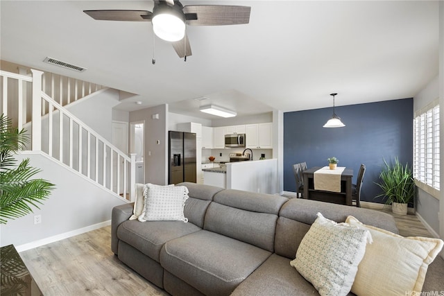 91-1031 Kaimalie St Unit 4M4, Ewa Beach, HI 96706 - living room featuring light wood-type flooring, stairway, and ceiling fan