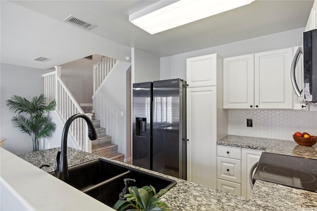 91-1031 Kaimalie St Unit 4M4, Ewa Beach, HI 96706 - kitchen featuring refrigerator with ice dispenser, stainless steel microwave, backsplash, white cabinetry, and light stone countertops