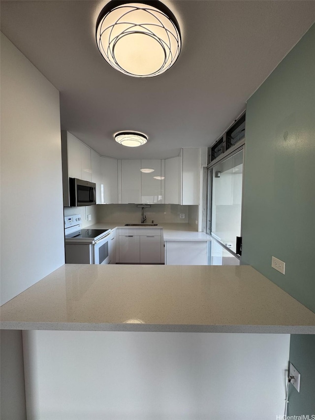 1519 Nuuanu Ave Unit 1146, Honolulu, HI 96817 - kitchen featuring electric stove, stainless steel microwave, white cabinetry, and light countertops