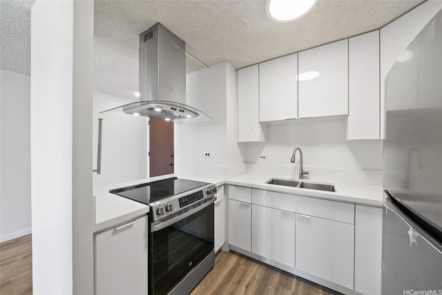 1535 Pensacola St Unit 208, Honolulu, HI 96822 - kitchen featuring appliances with stainless steel finishes, island range hood, white cabinets, wood finished floors, and light countertops