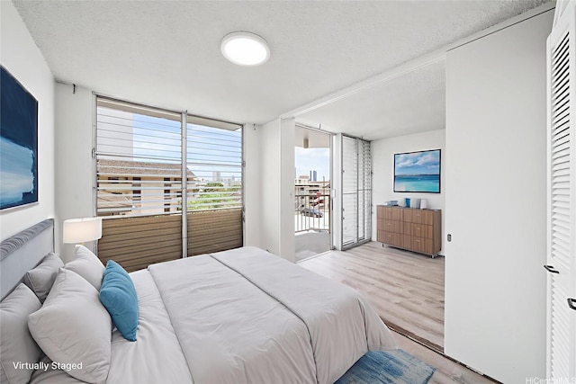 1535 Pensacola St Unit 208, Honolulu, HI 96822 - bedroom with light wood-type flooring and a textured ceiling