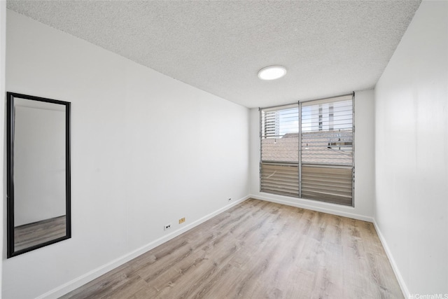 1535 Pensacola St Unit 208, Honolulu, HI 96822 - unfurnished room with a textured ceiling and light wood-style flooring