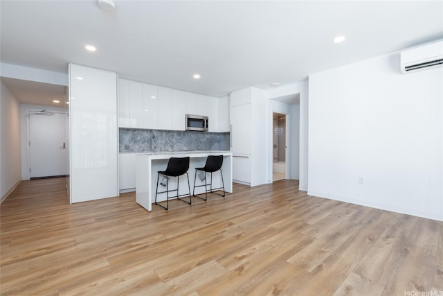 987 Queen St Unit 1512, Honolulu, HI 96814 - kitchen with stainless steel microwave, modern cabinets, light countertops, a kitchen island, and white cabinetry