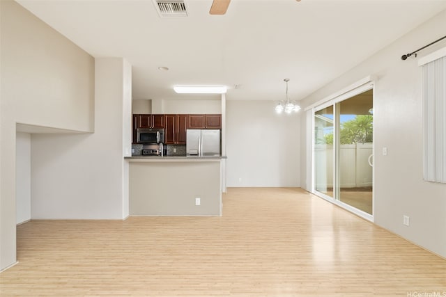 91-1200 Keaunui Dr Unit 208, Ewa Beach, HI 96706 - kitchen featuring light wood-style flooring, a chandelier, a peninsula, freestanding refrigerator, and hanging light fixtures