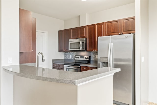 91-1200 Keaunui Dr Unit 208, Ewa Beach, HI 96706 - kitchen with appliances with stainless steel finishes, a peninsula, decorative backsplash, and light countertops
