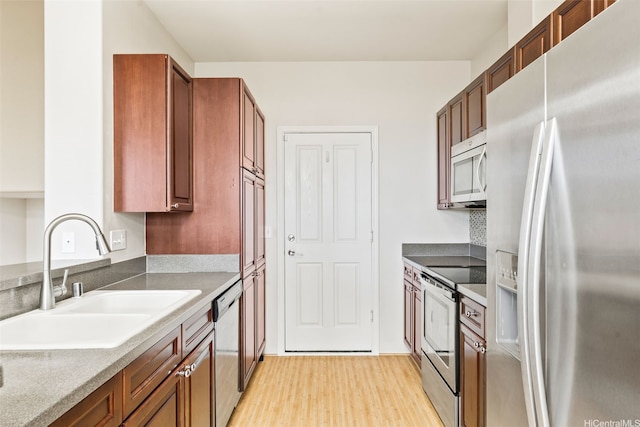 91-1200 Keaunui Dr Unit 208, Ewa Beach, HI 96706 - kitchen with appliances with stainless steel finishes, light wood-type flooring, and brown cabinets