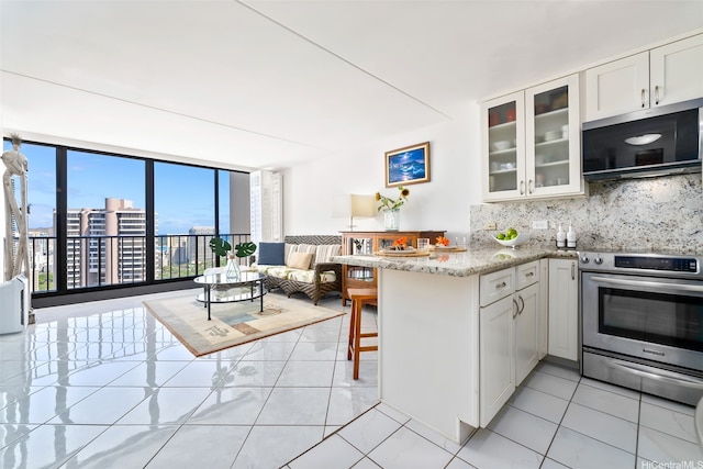 411 Hobron Ln Unit 3801, Honolulu, HI 96815 - kitchen featuring appliances with stainless steel finishes, a peninsula, backsplash, glass insert cabinets, and white cabinetry