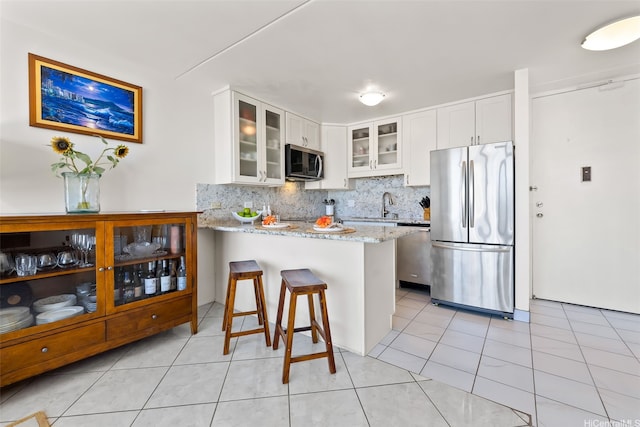 411 Hobron Ln Unit 3801, Honolulu, HI 96815 - kitchen with appliances with stainless steel finishes, a peninsula, light stone countertops, backsplash, and glass insert cabinets