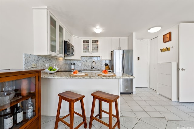 411 Hobron Ln Unit 3801, Honolulu, HI 96815 - kitchen with stainless steel appliances, a peninsula, glass insert cabinets, light stone countertops, and decorative backsplash