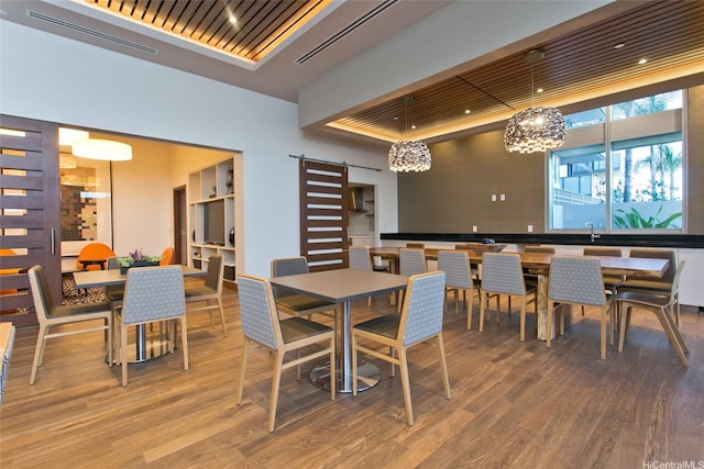 600 Ala Moana Blvd Unit 3401, Honolulu, HI 96813 - dining space featuring a barn door, wood finished floors, and a tray ceiling