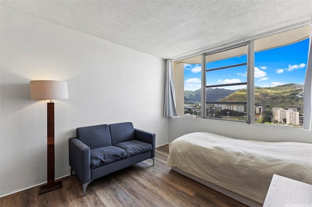 2825 S King St Unit 2504, Honolulu, HI 96826 - bedroom featuring a textured ceiling, wood finished floors, and a mountain view