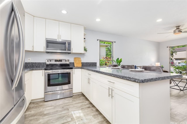 47-366 Hui Iwa St Unit 71, Kaneohe, HI 96744 - kitchen with appliances with stainless steel finishes, a peninsula, light wood finished floors, white cabinets, and recessed lighting