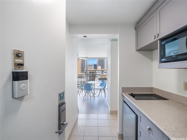 2427 Kuhio Ave Unit 1501, Honolulu, HI 96815 - kitchen with gray cabinets, light tile patterned flooring, light countertops, and black appliances