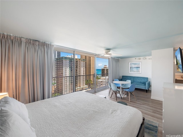 2427 Kuhio Ave Unit 1501, Honolulu, HI 96815 - bedroom with access to exterior, wood finished floors, ceiling fan, and expansive windows
