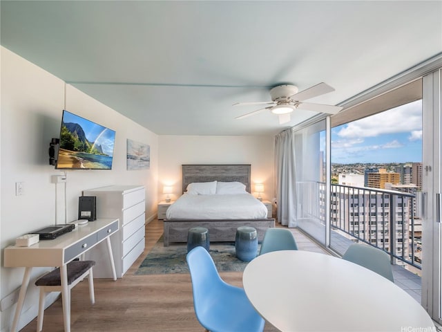 2427 Kuhio Ave Unit 1501, Honolulu, HI 96815 - bedroom featuring access to exterior, floor to ceiling windows, wood finished floors, and ceiling fan