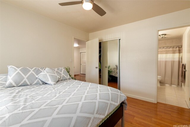239 Mananai Pl Unit 54F, Honolulu, HI 96818 - bedroom featuring a closet, connected bathroom, wood finished floors, and ceiling fan