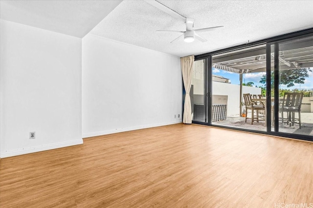 1600 Ala Moana Blvd Unit 306, Honolulu, HI 96815 - empty room featuring wood finished floors, ceiling fan, floor to ceiling windows, and a textured ceiling
