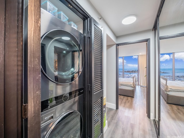 415 S St Unit 1602, Honolulu, HI 96813 - laundry room featuring estacked washer and dryer, wood finished floors, and a water view