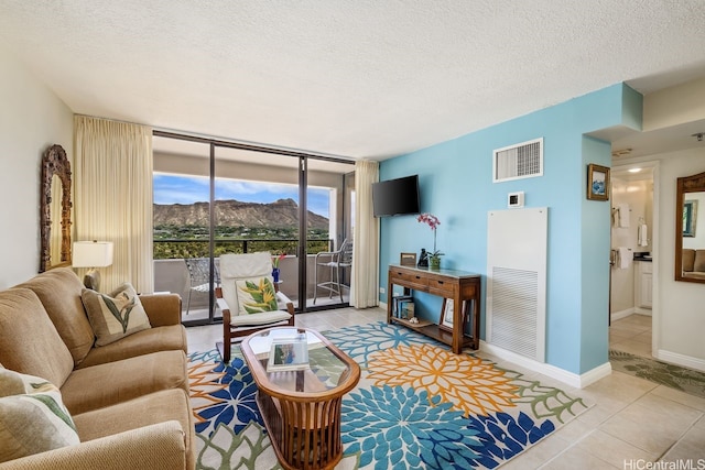 229 Paoakalani Ave Unit 1014, Honolulu, HI 96815 - living area featuring tile patterned floors, a wall of windows, and a textured ceiling